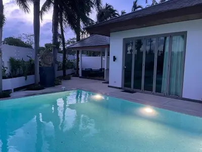 a swimming pool in front of a house at Beautiful villa walking distance from Bangtao Beach in Bang Tao Beach