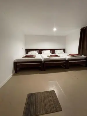 two twin beds in a room with a rug at Phi Phi Paradise Hostel in Phi Phi Don