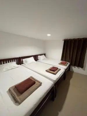 two twin beds in a room with two towels on them at Phi Phi Paradise Hostel in Phi Phi Don