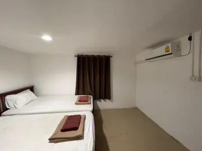 a small room with two beds and a window at Phi Phi Paradise Hostel in Phi Phi Don