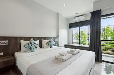 a bedroom with a large white bed with towels on it at De Piraya residence in Mai Khao Beach