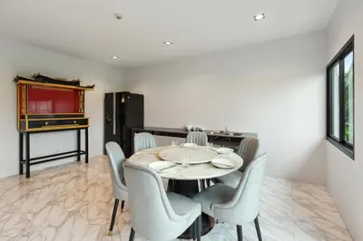 a dining room with a table and chairs at De Piraya residence in Mai Khao Beach