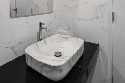 a bathroom with a marble sink and a mirror at De Piraya residence in Mai Khao Beach