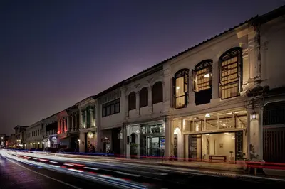 a city street at night with buildings and cars at 97 Yaowarat - Phuket Old Town in Phuket Town