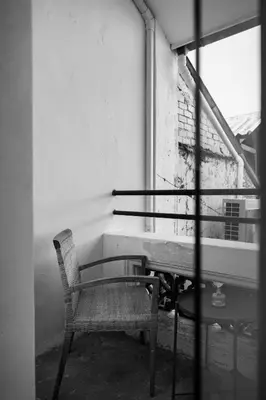 a table and chair in a room with a window at 97 Yaowarat - Phuket Old Town in Phuket Town