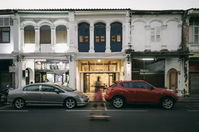two cars parked on a street in front of a building at 97 Yaowarat - Phuket Old Town in Phuket Town
