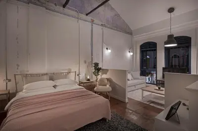 a bedroom with a large bed and a living room at 97 Yaowarat - Phuket Old Town in Phuket Town
