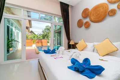 a bedroom with two beds with blue bows on them at Rawai Private Villas - Pools and Garden in Rawai Beach