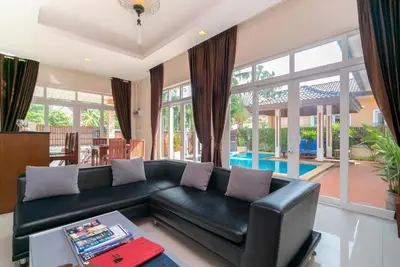 a living room with a black leather couch at Rawai Private Villas - Pools and Garden in Rawai Beach