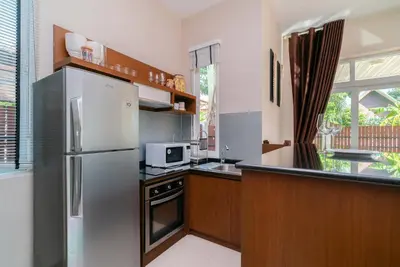 a kitchen with a stainless steel refrigerator and a microwave at Rawai Private Villas - Pools and Garden in Rawai Beach