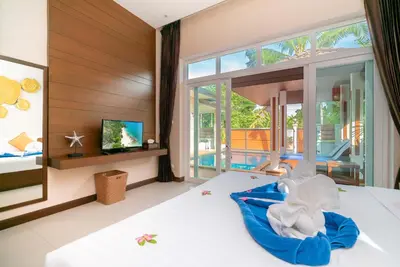 a bedroom with a bed and a tv and some windows at Rawai Private Villas - Pools and Garden in Rawai Beach