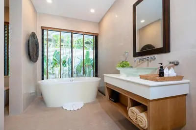 a bathroom with a tub and a sink and a mirror at Anchan Villas Phuket - Private 2 Bedroom Pool Villas by Escape Villas in Bang Tao Beach