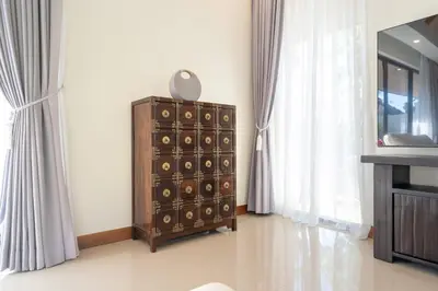 a room with a chest of drawers and a mirror at Anchan Villas Phuket - Private 2 Bedroom Pool Villas by Escape Villas in Bang Tao Beach