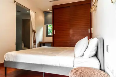 a bedroom with a large bed with a wooden headboard at The residence resort Villa 1bdr Private Pool in Phuket Town