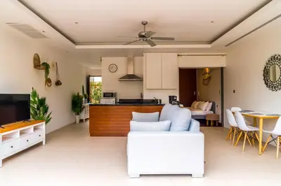 a living room with a couch and a kitchen at The residence resort Villa 1bdr Private Pool in Phuket Town