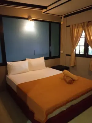 a bedroom with a large white bed with a window at PhiPhi Film House in Phi Phi Don