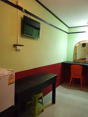 a room with a table and a tv on the wall at PhiPhi Film House in Phi Phi Don