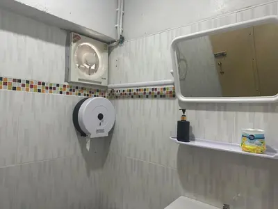 a bathroom with a toilet paper dispenser and a mirror at PhiPhi Film House in Phi Phi Don