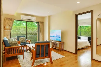 a room with a bedroom with a bed and a mirror at The Title Rawai Beachfront (Sea paradise) in Rawai Beach