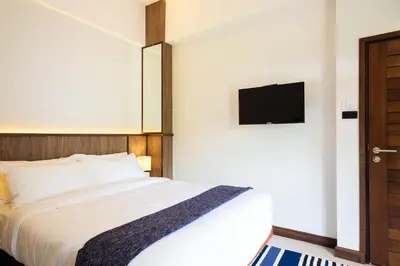 a bedroom with a bed and a flat screen tv at Baan Kamana Guest House in Phangnga