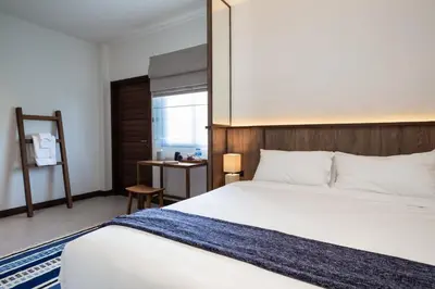 a bedroom with a large white bed and a window at Baan Kamana Guest House in Phangnga
