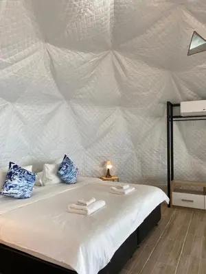 a bedroom with a large white bed with a wall at Touch Glamping Koh Yao Noi ทัช แกรมปิ้ง เกาะยาวน้อย in Ko Yao Noi