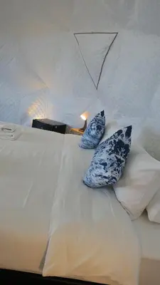 a bed with two blue and white pillows on it at Touch Glamping Koh Yao Noi ทัช แกรมปิ้ง เกาะยาวน้อย in Ko Yao Noi