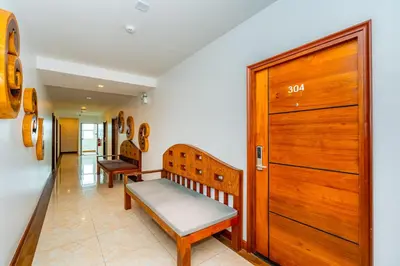 a hallway with two benches and a wooden door at The Cheetar Hotel in Amphoe Kathu