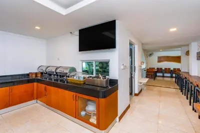 a kitchen with a counter with a tv on the wall at The Cheetar Hotel in Amphoe Kathu