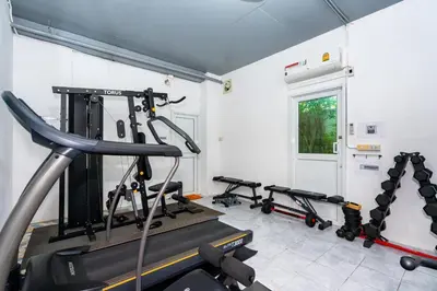 a gym with several tread machines in a room at The Cheetar Hotel in Amphoe Kathu