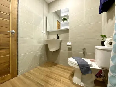 a bathroom with a toilet and a sink at Chonlada Holiday Home - 2 BR Pool Access Bungalow - Kamala Beach in Kamala Beach