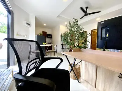 a living room with a dining room table and chairs at Chonlada Holiday Home - 2 BR Pool Access Bungalow - Kamala Beach in Kamala Beach