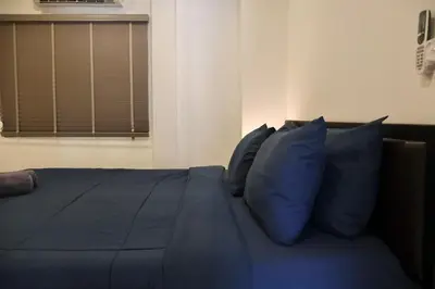 a blue bed with blue pillows in a bedroom at Chonlada Holiday Home - 2 BR Pool Access Bungalow - Kamala Beach in Kamala Beach