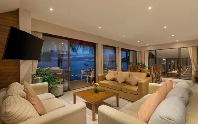 a living room with couches and a flat screen tv at Beachfront Kalim Beach Villa in Patong Beach