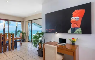 a living room with a desk with a laptop on it at Beachfront Kalim Beach Villa in Patong Beach
