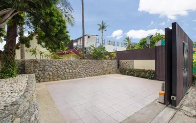 a stone retaining wall and a stone patio with a fence at Beachfront Kalim Beach Villa in Patong Beach