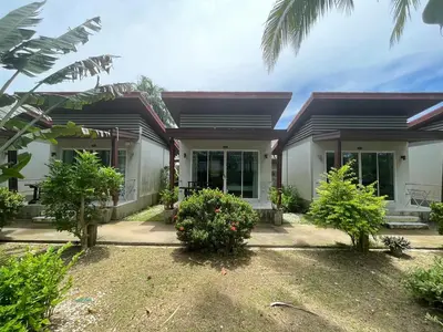 a house with trees and bushes in front of it at Naiyang Boutique Resort in Ban Phak Chit