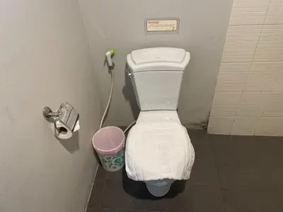 a bathroom with a toilet and a trash can at Naiyang Boutique Resort in Ban Phak Chit
