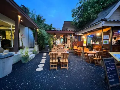 a restaurant with wooden tables and chairs in front of it at Naiyang Boutique Resort in Ban Phak Chit