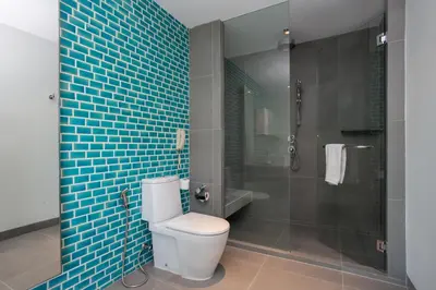 a bathroom with a toilet and a shower with blue tiles at Happy Apartment on Karon Beach in Karon Beach