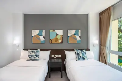 a bedroom with two beds and a painting on the wall at Happy Apartment on Karon Beach in Karon Beach