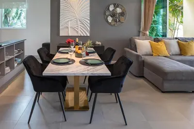 a dining room with a table and chairs and a couch at Happy Apartment on Karon Beach in Karon Beach