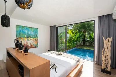 a bedroom with a bed and a swimming pool at Eden Escape Naiyang Beach in Phuket Town