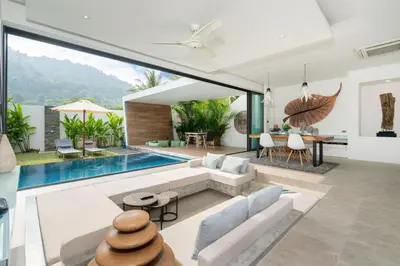 an open living room with a swimming pool and a house at Eden Escape Naiyang Beach in Phuket Town