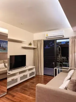 a living room with a television and a couch at The Title Rawai: Beachfront condotel in Rawai Beach