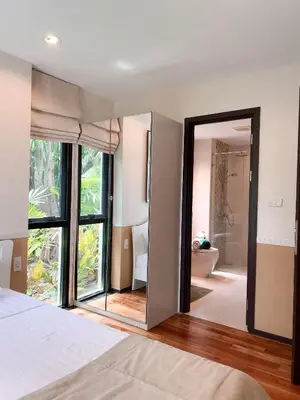 a bedroom with a large mirror and a bathroom at The Title Rawai: Beachfront condotel in Rawai Beach