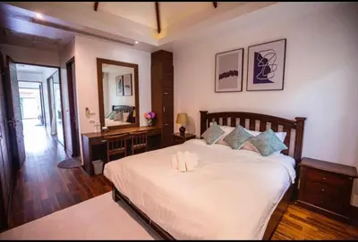 a bedroom with a large white bed and a desk at Poly Villa Naya 3 in Rawai Beach
