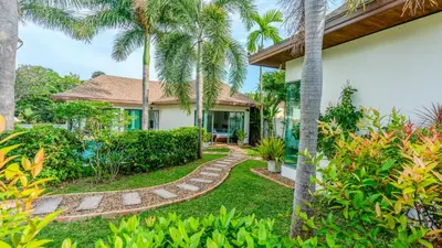 a house with a garden with palm trees at Poly Villa Naya 3 in Rawai Beach