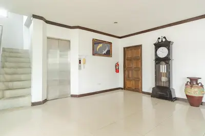 a hallway with a grandfather clock and a staircase at Goodday Kathu in Kathu