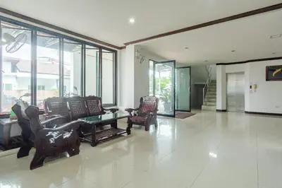 a living room with chairs and a table and windows at Goodday Kathu in Kathu